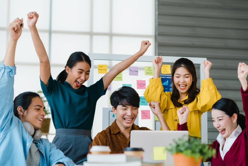 Team celebrating around a project board after a successful launch